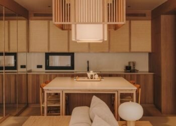 La puerta de una biblioteca oculta oculta las habitaciones de un apartamento minimalista en Barcelona