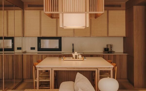 La puerta de una biblioteca oculta oculta las habitaciones de un apartamento minimalista en Barcelona