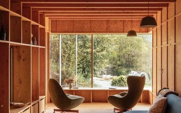 Ocho interiores de cabañas llenos de luz definidos por generosas ventanas